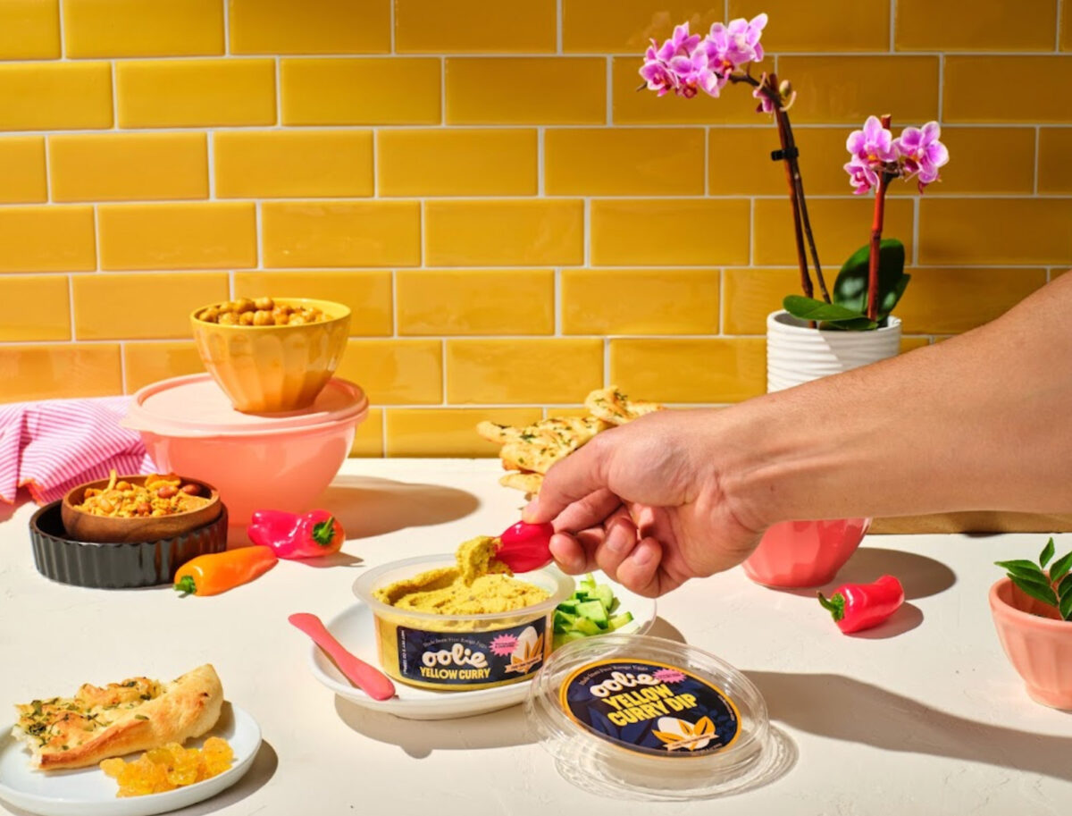 hand holding pepper dipping into a container of Oolie dip